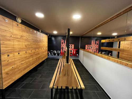 a room with a wooden bench in a gym at Apartment and Rooms In Club in Inđija
