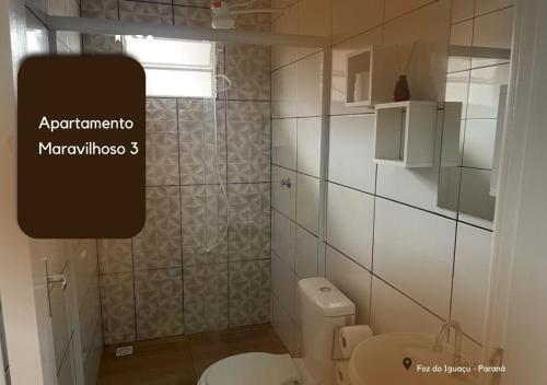 La salle de bains est pourvue d'une douche et de toilettes blanches. dans l'établissement APARTAMENTO MARAVILHOSO 3, à Foz do Iguaçu