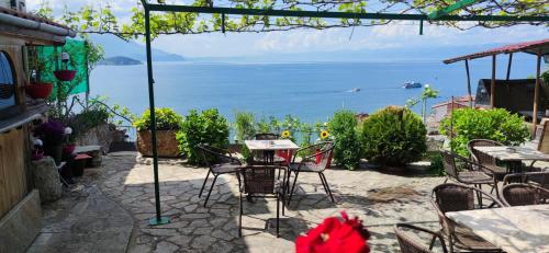 a patio with tables and chairs and a view of the ocean at Villa Malezan in Ohrid