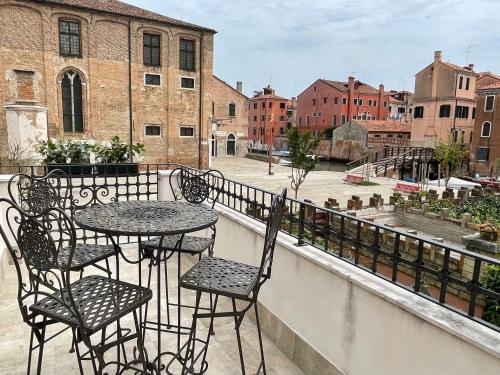patio ze stołami i krzesłami na balkonie w obiekcie MH 3202 w Wenecji