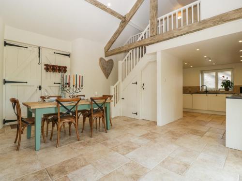 a kitchen and dining room with a table and chairs at The Hayloft in Honiton