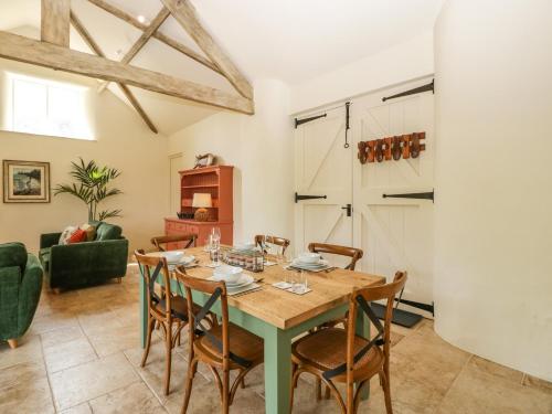 a dining room with a table and chairs at The Hayloft in Honiton