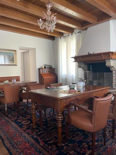 a dining room with a table and chairs and a piano at VILLA MARGHERITA in Pieve di Soligo