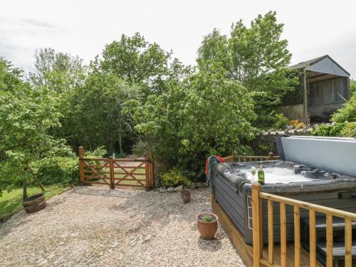a backyard with a hot tub and a fence at The Hayloft in Honiton