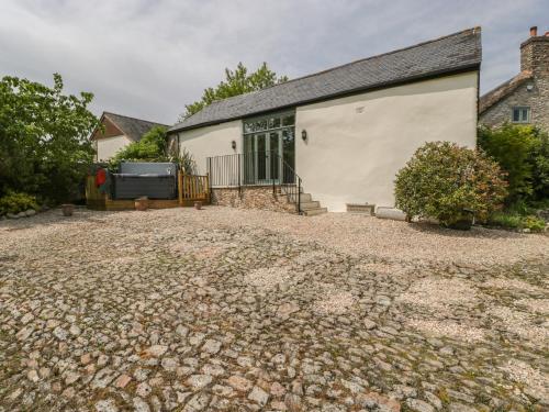 a house with a gravel driveway in front of it at The Hayloft in Honiton