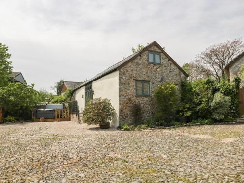 an old stone house with a gravel driveway at The Hayloft in Honiton