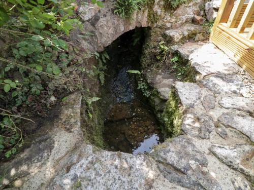 a small hole in the rocks with a tunnel in it at The Hayloft in Honiton