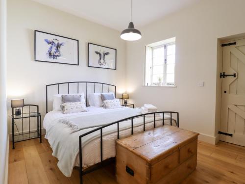 um quarto com uma cama grande e piso em madeira em The Old Dairy Cottage em Dartford