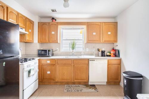 a kitchen with wooden cabinets and a black refrigerator at Daphy Ruby Stays in Newark