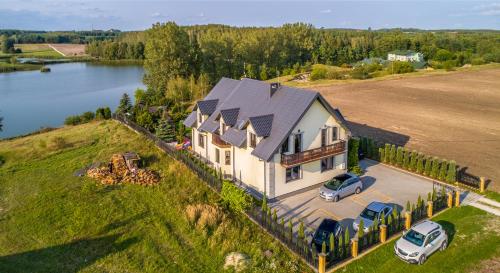 una vista aerea di una casa su una collina con un lago di Gospodarstwo Agroturystyczne Domek na Wzgórzu a Chmielnik