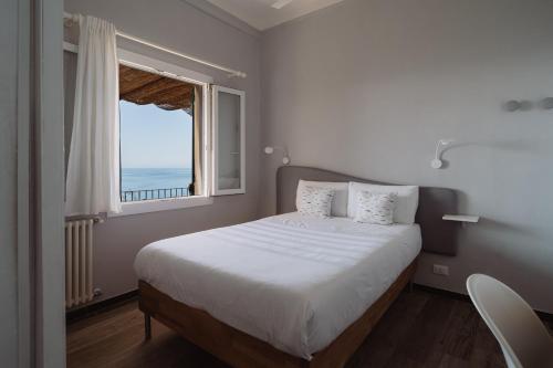 ein Schlafzimmer mit einem großen Bett und einem Fenster in der Unterkunft Villa Solaria in Sori