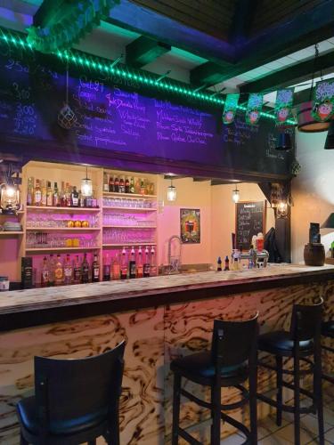 un bar avec des chaises dans un bar avec des lumières violettes dans l'établissement Studio GREEN, à Obersaasheim