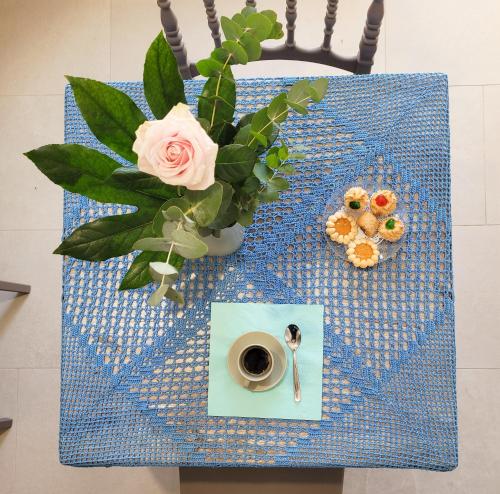 a table with a vase of flowers and a cup of coffee at ROSSINI GUEST HOUSE in Martina Franca