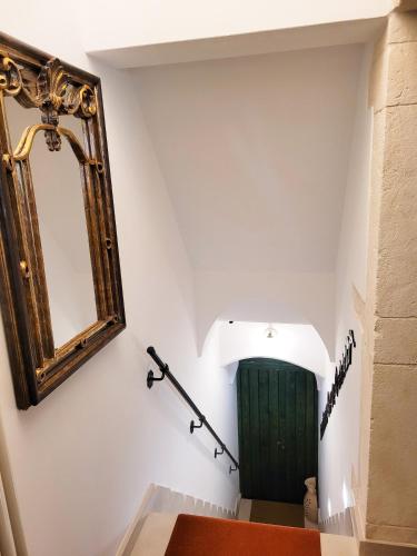 a stairwell with a mirror and a green door at ROSSINI GUEST HOUSE in Martina Franca