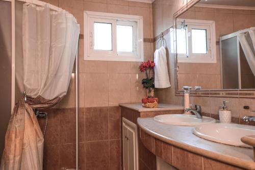 ein Bad mit 2 Waschbecken und einer Dusche in der Unterkunft Chrysanthi's House in Áyios Kírikos