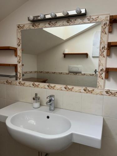 uma casa de banho com um lavatório branco e um espelho. em B&B Artincentro em Lodi