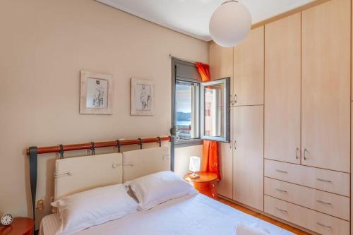 a bedroom with a bed and a window at Anavissos Seaview Holiday Home in Anavissos