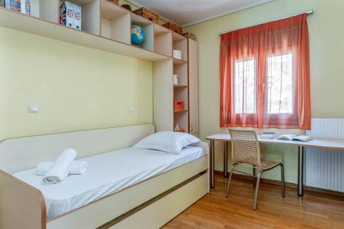 a bedroom with a bed and a desk and a chair at Anavissos Seaview Holiday Home in Anavissos