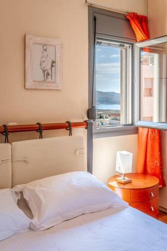 a bedroom with a bed and a window at Anavissos Seaview Holiday Home in Anavissos