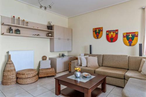 a living room with a couch and a table at Anavissos Seaview Holiday Home in Anavissos