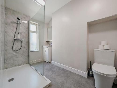 a white bathroom with a shower and a toilet at Rose House - By Sigma Stays in Crewe