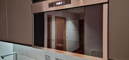 - un miroir au-dessus d'un lavabo dans la salle de bains dans l'établissement Lugar de Alegría, Pegado a Playa, 2 Hab, 6 p, Wifi, à Gijón