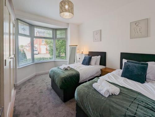 a bedroom with two beds and a window at Rose House - By Sigma Stays in Crewe