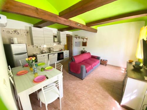 a kitchen and a living room with a red couch at Cascina Bramasole in Celle Enomondo
