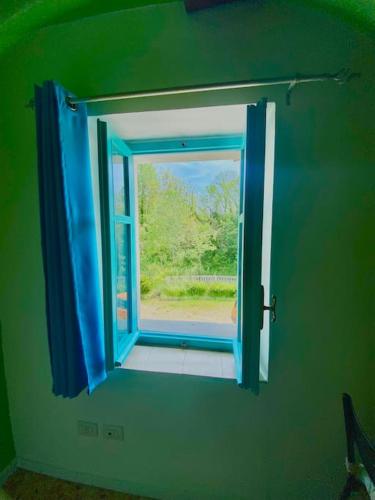 a blue window in a green room with a view at Cascina Bramasole in Celle Enomondo