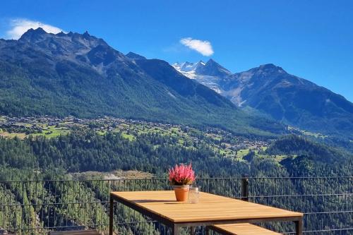 Mattertal Lodge في Embd: طاولة على شرفة مطلة على الجبال