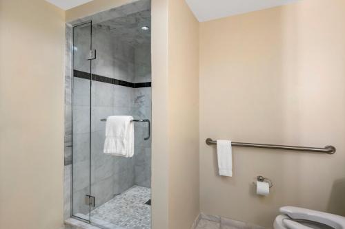 a bathroom with a shower with a glass door at Wyvern Hotel, an Ascend Collection Hotel in Punta Gorda