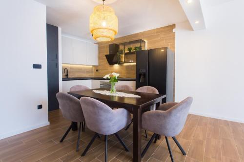 eine Küche und ein Esszimmer mit einem Tisch und Stühlen in der Unterkunft Angolo Apartments in Kaštela