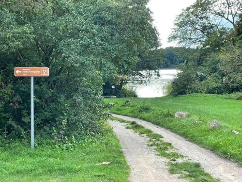 a dirt road with a sign next to a lake at Gemütliches Haus max 6 Personen 2Schlafzimmer 1Schlafsofa in Klocksin