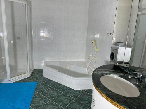 uma casa de banho com um lavatório, um chuveiro e uma banheira em Gemütliches Haus mit Parkplatz auf dem Hof em Klocksin