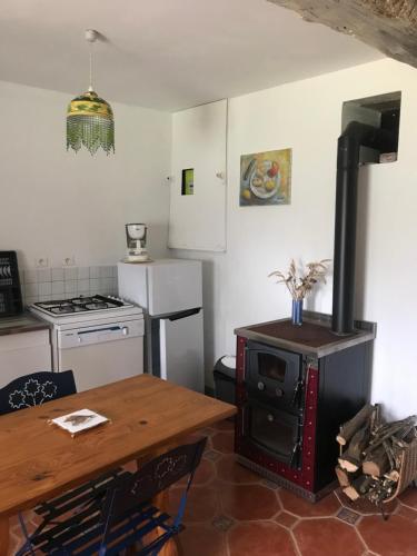 Il comprend une cuisine équipée d'une cuisinière et d'une table en bois. dans l'établissement Réveil aux chants des oiseaux, à Assé-le-Riboul