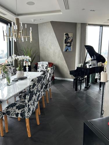 a dining room with a table and a piano at Parliament House - Luxury Penthouse in London