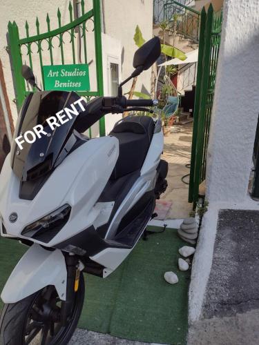 a white scooter parked next to a building at Art Studios Benitses in Benitses
