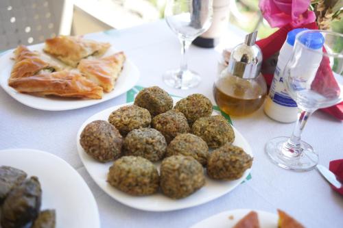 a table with plates of food and glasses of wine at Grandma's Home in Gjirokastër