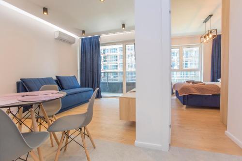 比亚韦斯托克Urban Jungle apartament Alice的客厅里有一张桌子和一张蓝色沙发