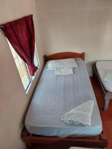 a small bedroom with a bed and a window at Guest House Nena in Moyogalpa