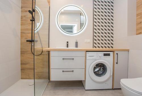 W łazience znajduje się pralka i lustro. w obiekcie Urban Jungle apartament Alice w mieście Białystok