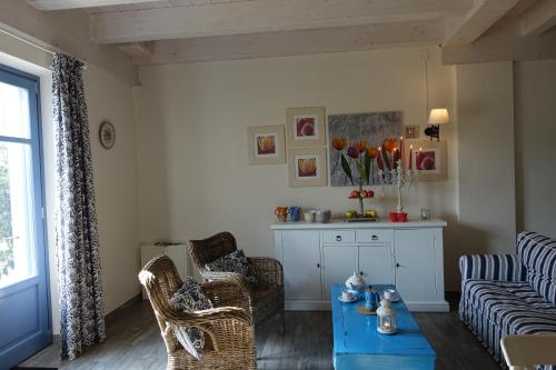 a living room with a couch and chairs and a table at Cascina Arcangelo Raffaele in Verduno