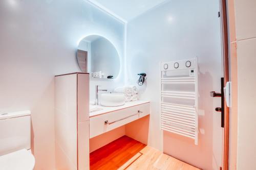 małą łazienkę z umywalką i lodówką w obiekcie Villas de Provence - Maison avec piscine chauffée "Nirvana Pop Art" w mieście LʼIsle-sur-la-Sorgue