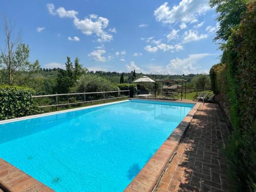 una piscina de agua azul en un patio en Villa Ledonia, en Montaione