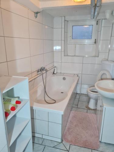 a bathroom with a tub and a toilet and a sink at Ramstein Wohnung in Ramstein-Miesenbach