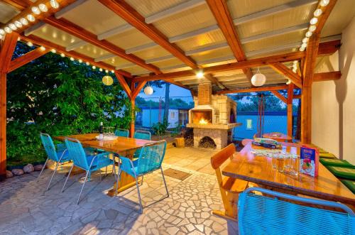 a patio with a table and chairs and a fireplace at Apartmani Sunčica Selce in Selce