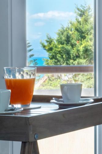 a table with a drink and two cups on a window at Butterfly House in Trappeto