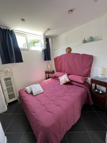 a bedroom with a large bed with a pink comforter at Arabesque in Lacco Ameno