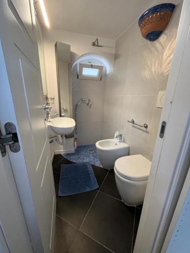 a bathroom with two sinks and a toilet and a sink at Arabesque in Lacco Ameno