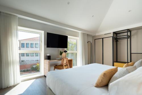 The Editory Garden Porto Hotel في بورتو: غرفة نوم بسرير كبير ونافذة كبيرة